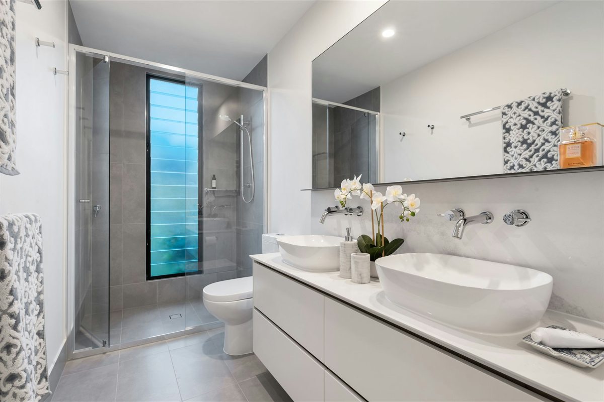 Finished bathroom renovation with glass shower and double vanity