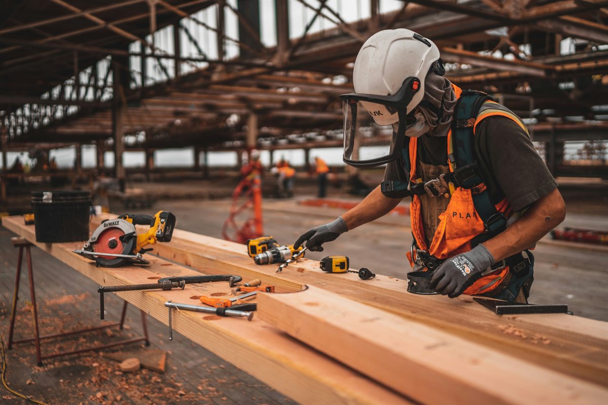 Builder measuring timber on a work bench